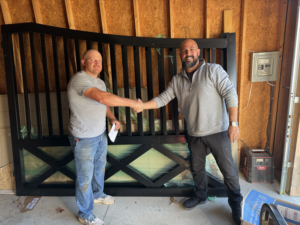 A customer shaking hands with a representative upon receiving a new metal gate from All With Us LLC in Green Cove Springs, FL.