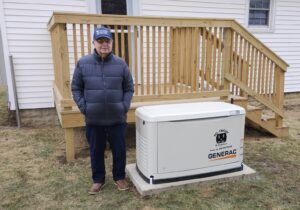 A satisfied customer standing next to a newly installed Generac standby generator by All Circuit Electrical LLC in Bryant, IN.