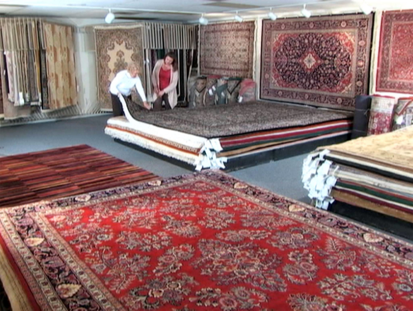 Customers selecting an oriental rug in the showroom at Demanes Oriental Rugs in Peoria, IL