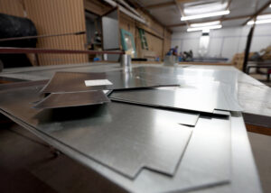 Precisely cut sheet metal pieces ready for fabrication into HVAC ductwork at Carlsbad Heating & Cooling in Carlsbad, NM.
