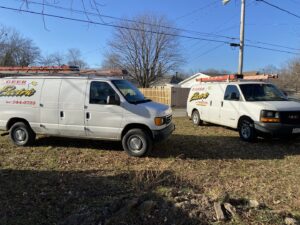 Two D. Geer Electric Inc. service vans with ladders parked, ready for or returning from an electrician job in Waukegan, IL.