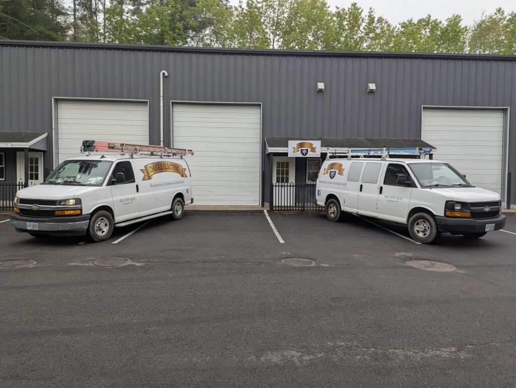Two branded Daigle Electric service vans with ladders, ready for electrician jobs in Middleboro, MA.