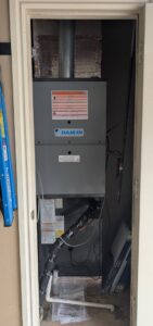 A Daikin furnace and air handler unit installed in a utility closet by Totality Heating And Cooling in Edmond, OK.