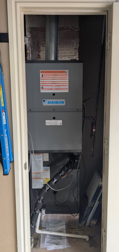 A Daikin furnace and air handler unit installed in a utility closet by Totality Heating And Cooling in Edmond, OK.