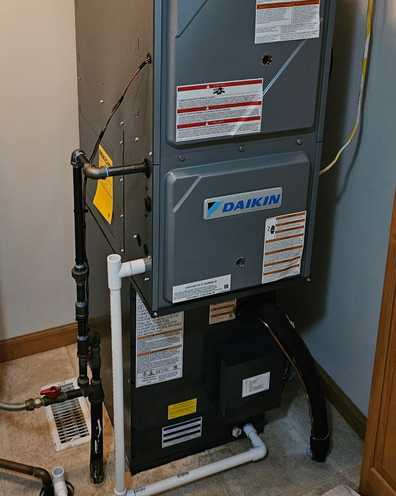An indoor Daikin HVAC furnace and air handler unit installed by Dixon's Heating & Air Conditioning, Inc. in Athens, IL