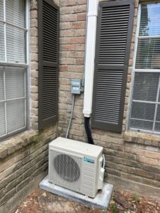 A Daikin mini-split air conditioning unit newly installed outside a brick home by ProTexAir HVAC Services in Houston, TX.