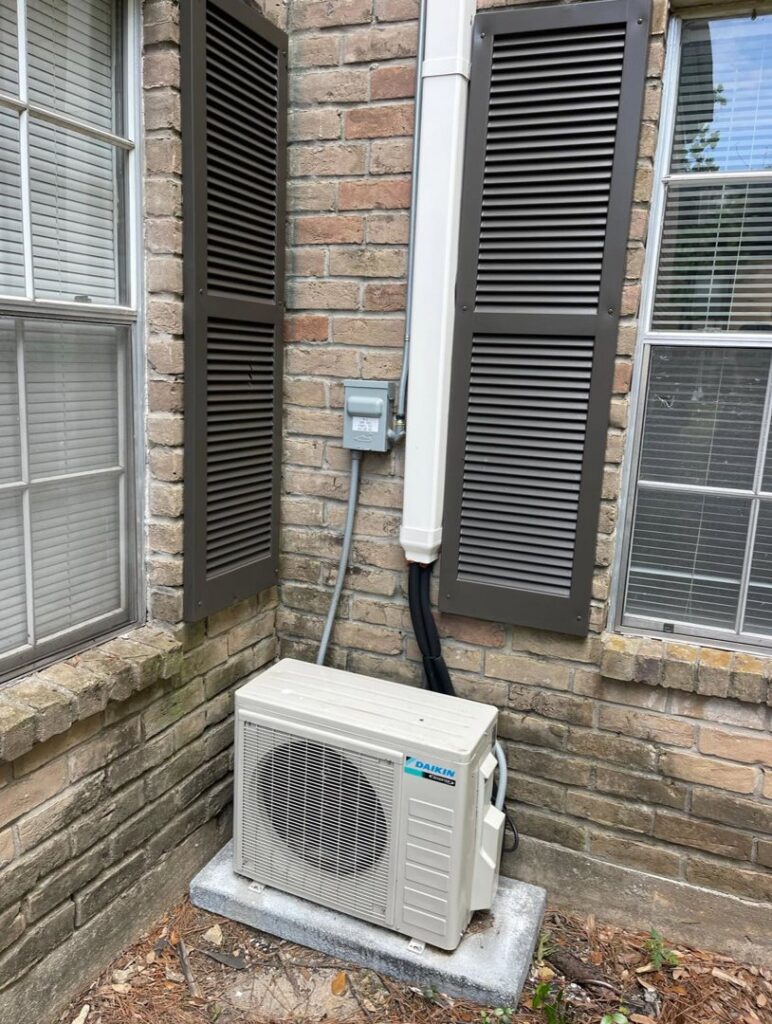 A Daikin mini-split air conditioning unit newly installed outside a brick home by ProTexAir HVAC Services in Houston, TX.