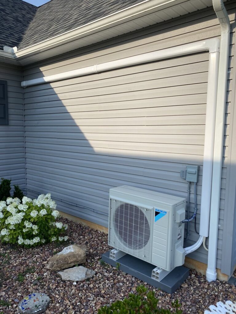 An outdoor Daikin mini-split condenser unit installed next to a residential building by Grozier Heating and Air Conditioning, LLC in Allentown, PA.