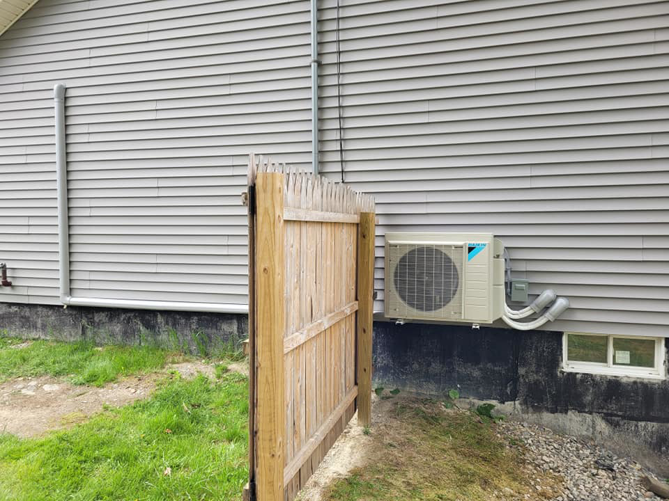 A Daikin mini-split condenser unit installed on the exterior of a home by Maine Thermal Energy Services in Ellsworth, ME