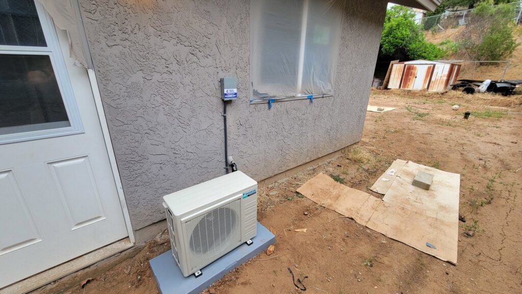 A Daikin mini-split condenser unit installed outside a residential building by Peace & Comfort Heating and Air in San Diego, CA.