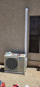A Daikin mini-split outdoor condenser unit with tools on top, indicating service by HoxAir Heating & Cooling in Phoenix, AZ