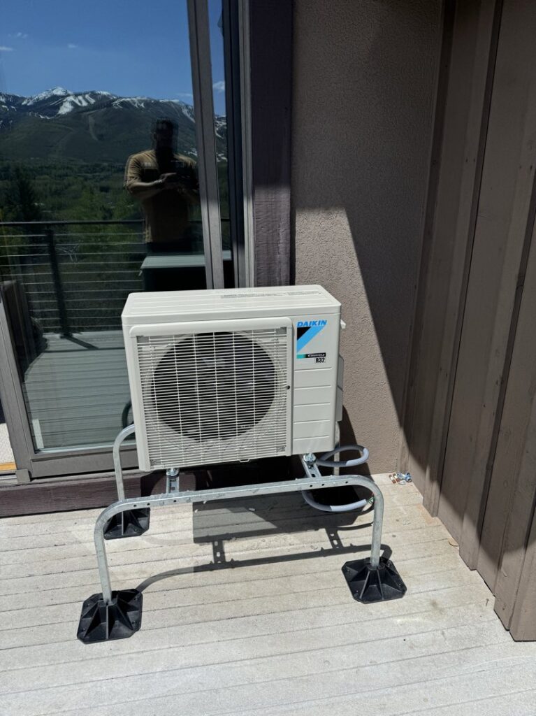 A Daikin mini-split outdoor condenser unit installed on a stand on a deck by EPIC Heating and Air in Loveland, CO
