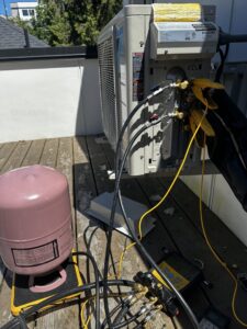 An HVAC technician performing maintenance on a Daikin mini-split unit for JN Heating & Cooling in Eure, NC
