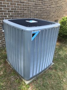 A Daikin outdoor HVAC unit installed next to a brick house by All American Heating and Air in Warner Robins, GA.