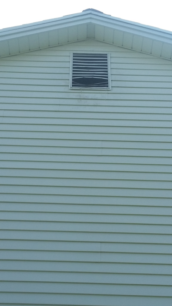 A damaged attic vent on a house, indicating a potential wildlife entry point addressed by AccuPest Pest Control in Waterbury, CT.