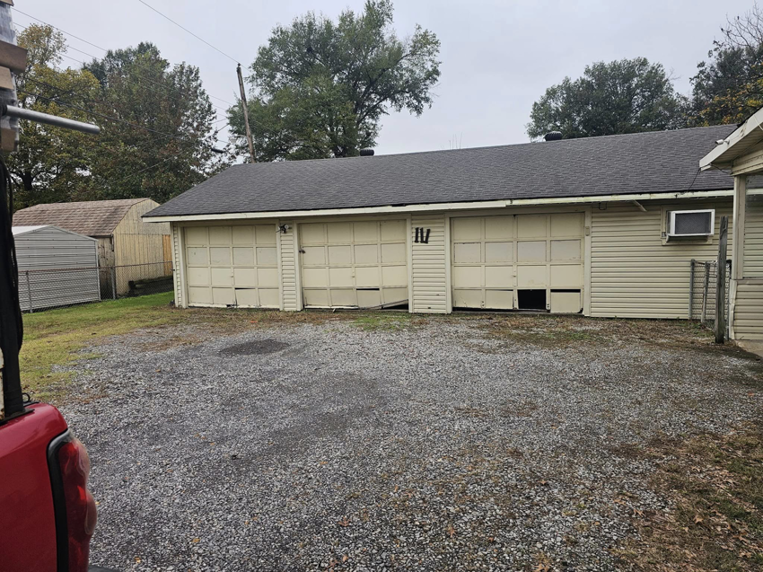 Damaged beige garage doors needing repair or replacement by The Garage Man in Memphis, TN.
