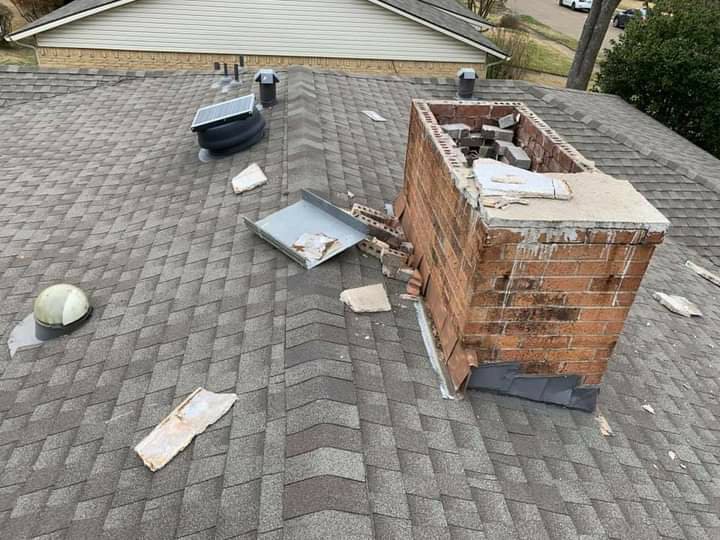 A severely damaged brick chimney on a residential roof, showing fallen bricks, repaired by A Step Above Chimney & Siding in Wichita, KS.