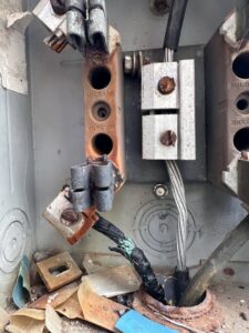 A close-up of a damaged and burnt electrical connection, indicating a critical repair job by LOJ Electric, LLC in Houston, TX.