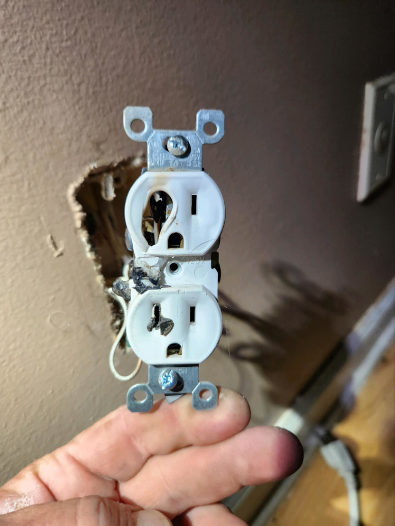 A severely damaged and burnt electrical outlet requiring repair by Wire Nutz LLC in Vancouver, WA