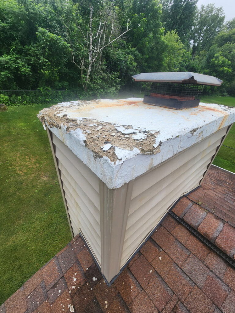 A damaged chimney crown with peeling concrete, showing need for repair by JJ Chimney Services in Minneapolis, MN.