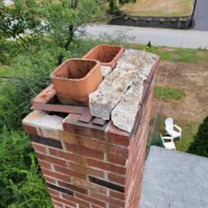 A damaged chimney top, a common entry point for wildlife, inspected by New England Wildlife Control in Salem, NH.