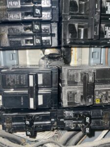 Close-up of damaged circuit breakers in an electrical panel, showing a repair need by Revamp Athens Electrical Company in Athens, GA.