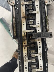 A close-up view of a damaged electrical panel bus bar, showing signs of electrical fault, serviced by 3C Electric Systems in Hartford, CT.