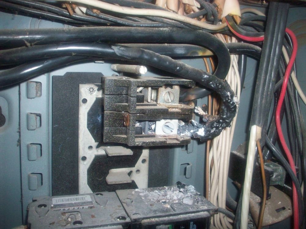 A damaged electrical panel with burnt wires requiring repair by Grace Electric Co. in Des Moines, IA.