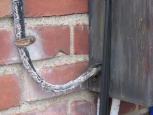 Damaged electrical wiring entering a service box on a brick wall, a common repair for Mac Electric Company in Warren, MI.