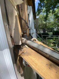 Damaged exterior electrical conduit and wiring on a building, indicating a need for repair by Copper Canyon Electric in Farmington, UT.