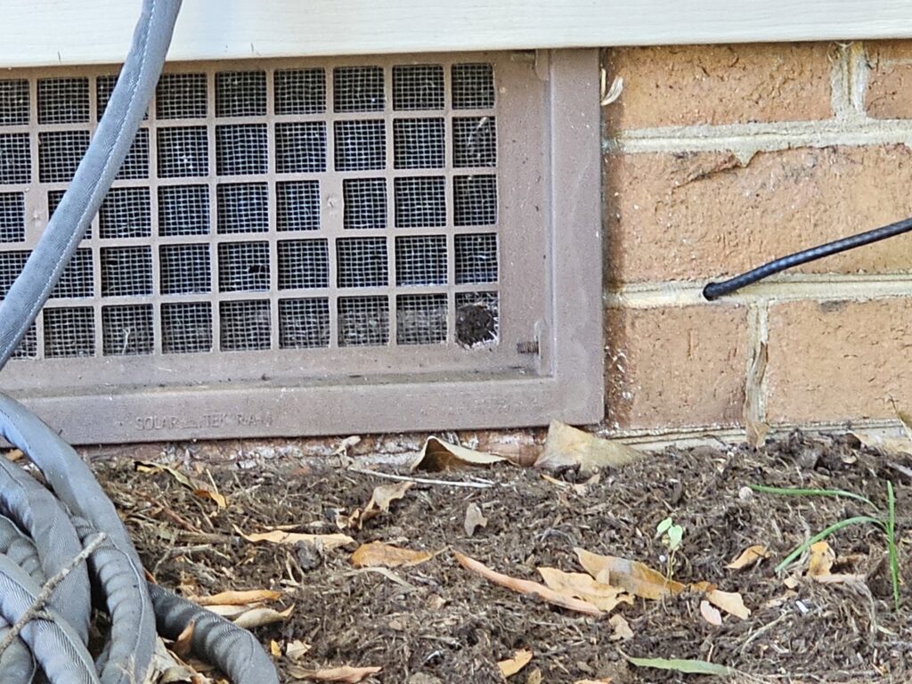 A damaged foundation vent screen, a common entry point for pests and wildlife, inspected by 1 Pest Solution in Winston-Salem, NC.