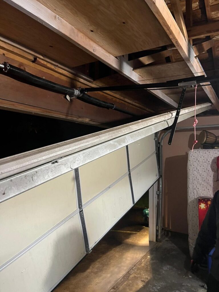 A damaged garage door off its tracks, requiring repair from AAA Garage Door Services in Renton, WA