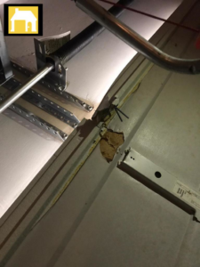Close-up of a damaged garage door panel showing a crack, indicating a repair job by TH Locksmith And Garage Door Repair, Vancouver, WA.