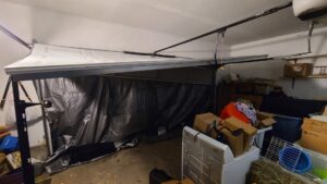 A damaged garage door undergoing repair or replacement by Revolution Garage Door, LLC in Corvallis, OR.