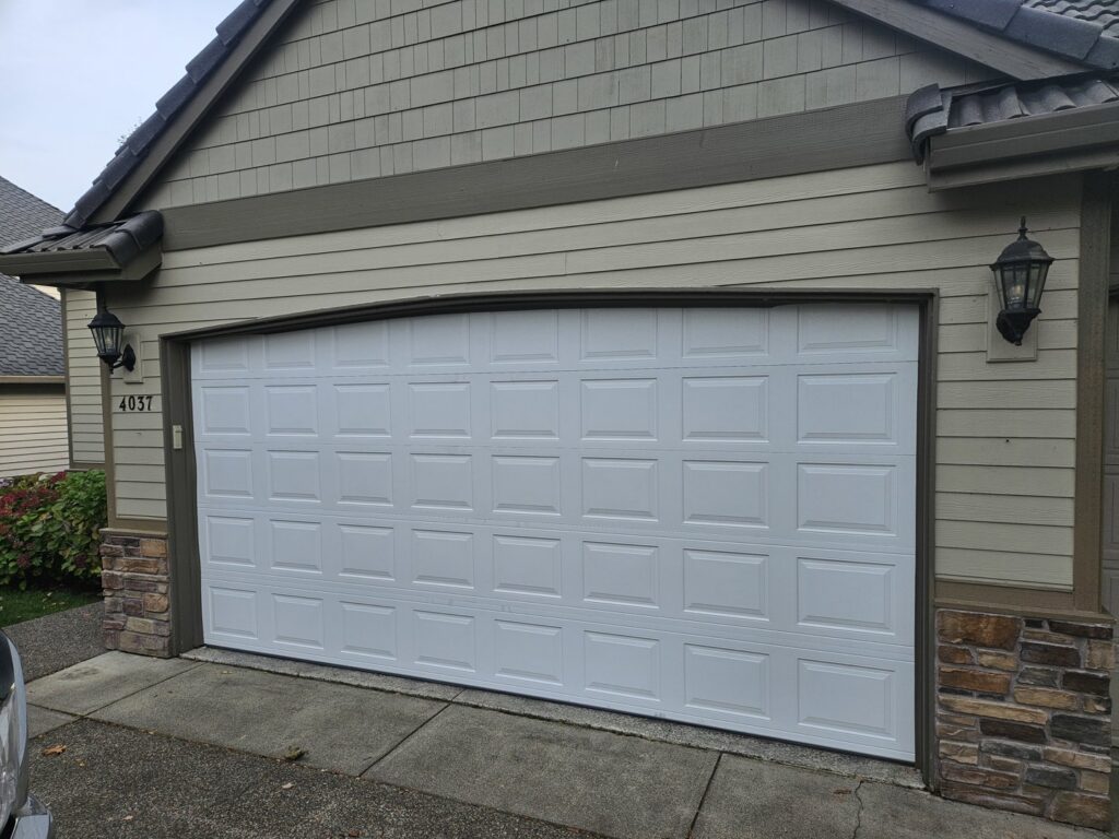 A close-up of a damaged garage door track and panel, indicating a need for repair by Alliance Overhead Garage Doors Inc. in Portland, OR.
