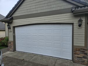 A close-up of a damaged garage door track and panel, indicating a need for repair by Alliance Overhead Garage Doors Inc. in Portland, OR.
