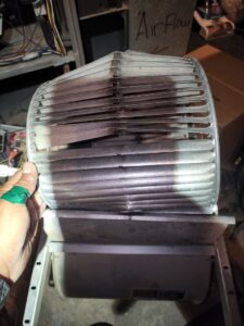 A damaged HVAC blower wheel, indicating a repair or replacement job by Service Champions Heating & Cooling in Aurora, IL.