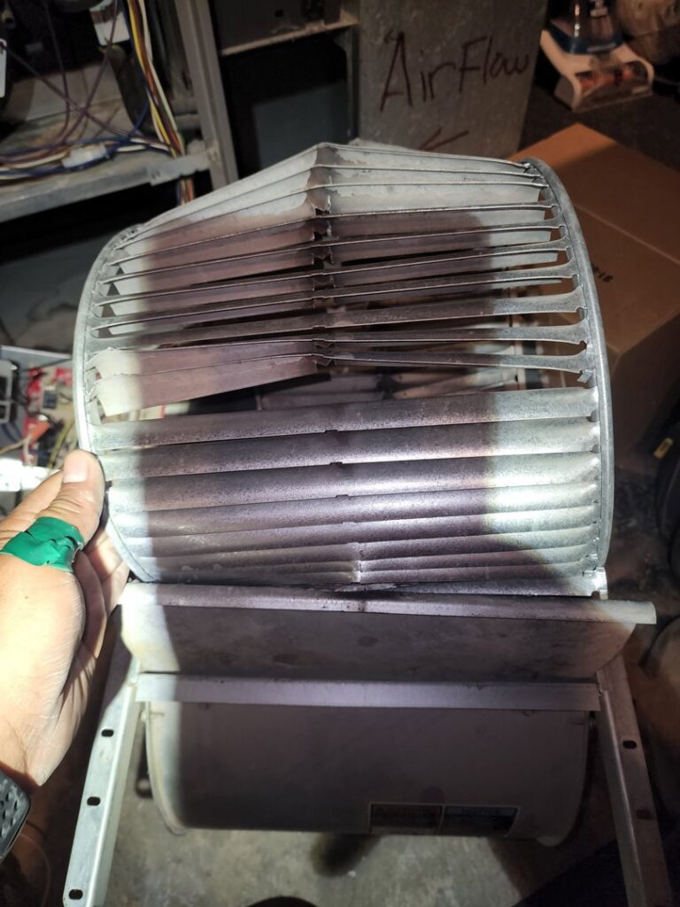 A damaged HVAC blower wheel, indicating a repair or replacement job by Service Champions Heating & Cooling in Aurora, IL.