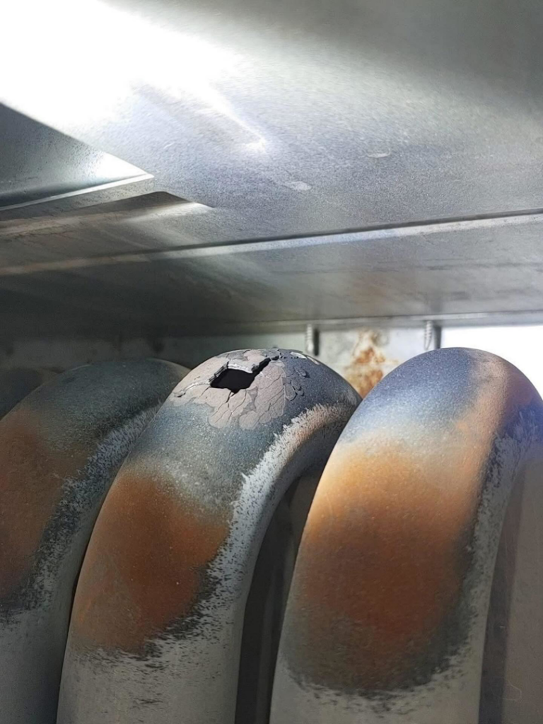 A close-up view of a damaged HVAC coil requiring repair by AP HVAC in Ridgewood, NY.