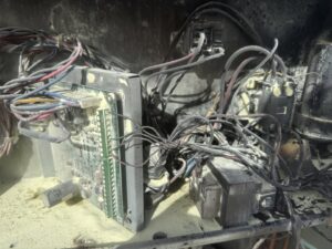A close-up view of a damaged and dirty HVAC electrical board and wiring, indicating a need for service by Four Corners Service Co. in Farmington, NM.