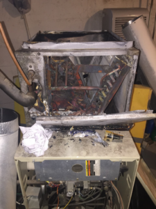 A severely damaged or burnt HVAC furnace unit, indicating a need for repair or replacement by Spencer Heating & Air Conditioning in Norcross, GA.