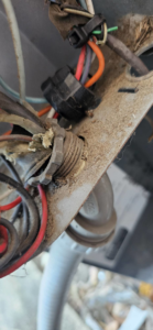 Damaged electrical wiring and conduit entry on an HVAC unit, ready for repair by Anubis Mechanical in Goose Creek, SC.