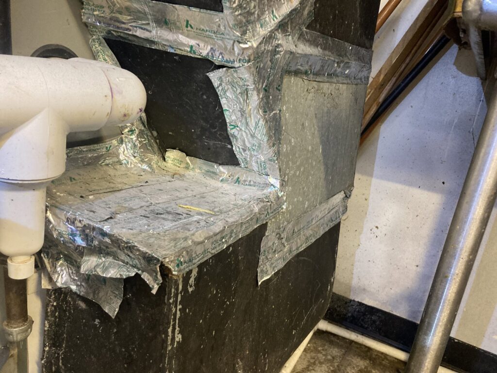 Damaged insulated HVAC ductwork connection, indicating a need for repair from Manny Services in Syracuse, NY.