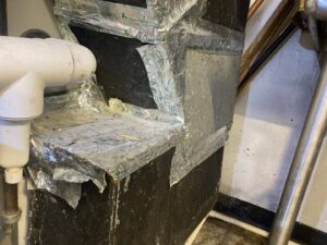 Damaged insulated HVAC ductwork connection, indicating a need for repair from Manny Services in Syracuse, NY.