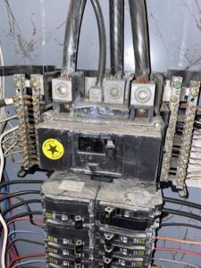 A close-up of a damaged main electrical panel and breaker box, indicating a need for service from AA Electric Contractors in Chicago, IL.