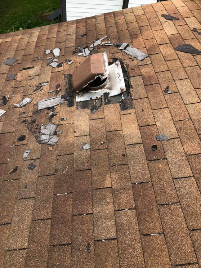 A damaged roof vent and shingles, likely from wildlife entry, handled by National Wildlife Control in Lansing, MI.