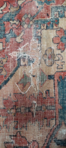 A severely damaged rug with torn fibers, ready for restoration by George Bell Rug Cleaning & Restoration in Jackson, MS.