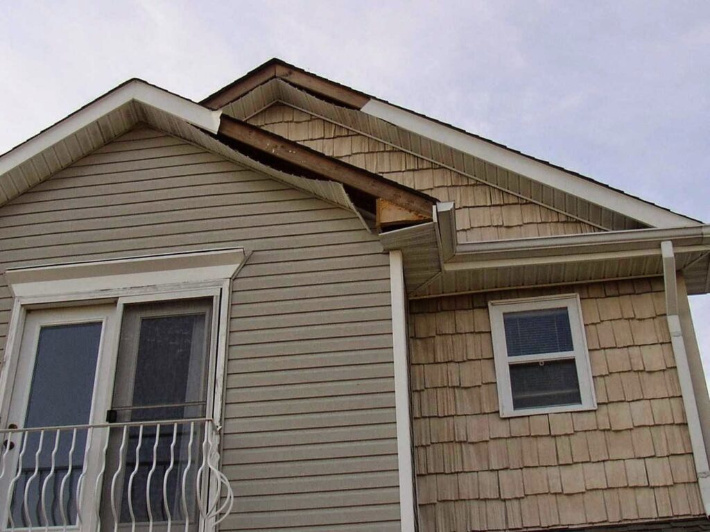 Damaged siding and roofline on a house, showing a wildlife entry point for ZooPro Wildlife Removal in Virginia Beach, VA.