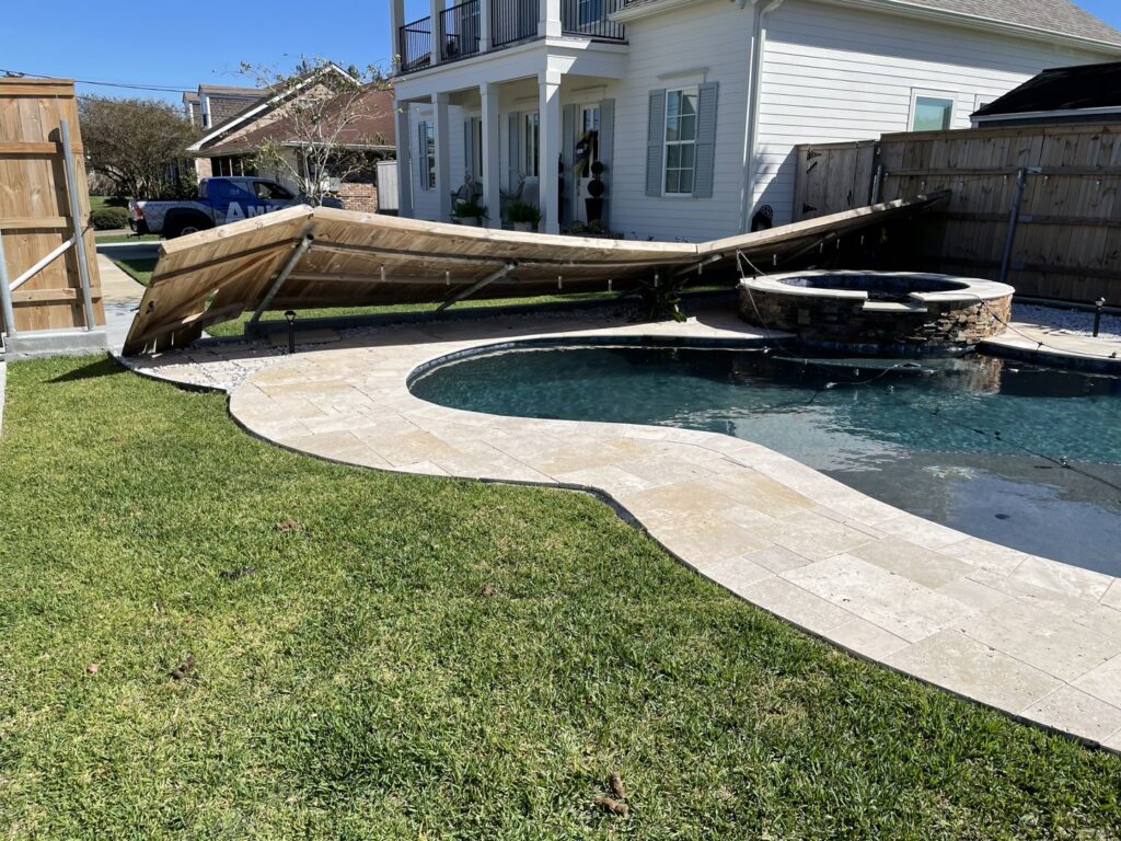 A damaged wooden fence surrounding a swimming pool, indicating a need for repair or replacement by Amko Fence Co. in Kenner, LA.