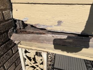 Damaged wooden siding and trim on a house exterior, indicating potential pest or wildlife damage for BBK Pest Control in Dallas, TX.